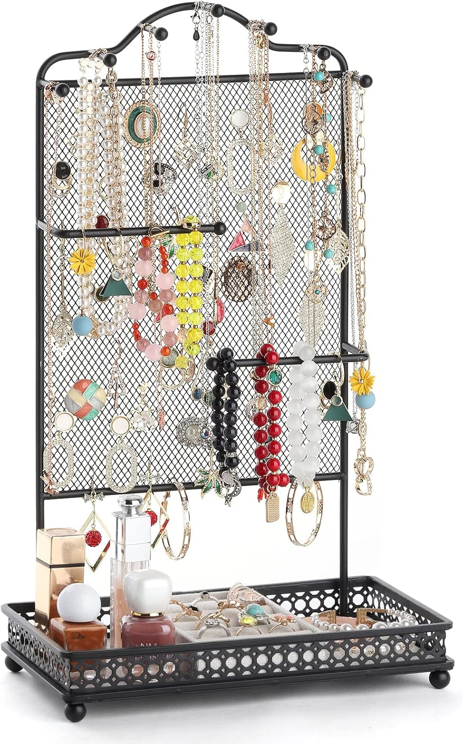 Black metal mesh jewelry organizer on a decorative tray loaded with necklaces, bracelets, rings and small bottles.
