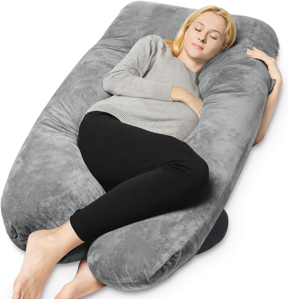 Top-angle view of a woman reclining inside a large gray U-shaped maternity pillow