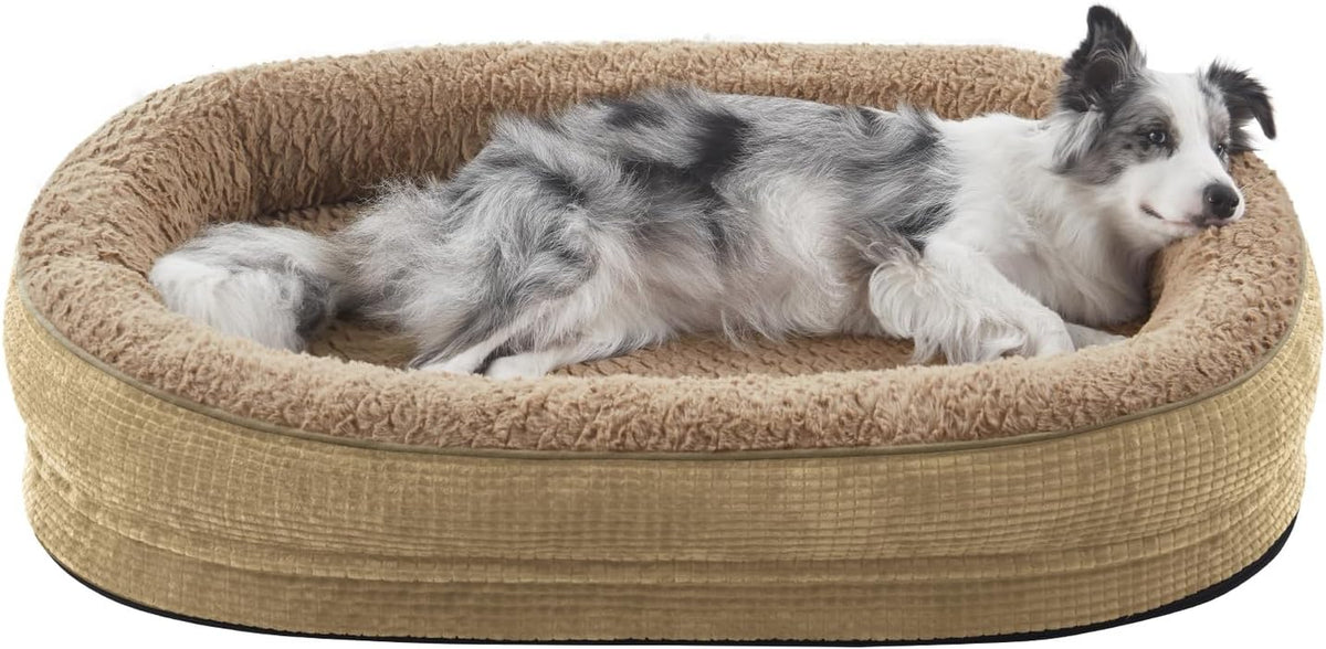Black-and-white dog lying in a tan oval bolster dog bed with plush inner lining.