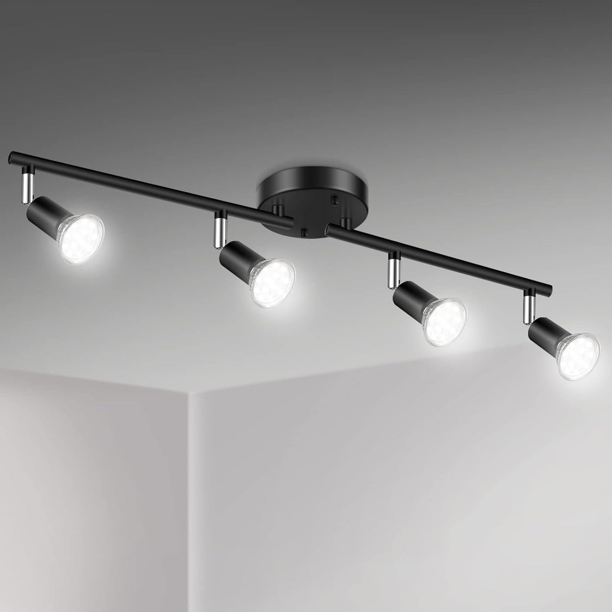 Studio view of a four‑head black track light bar with adjustable spot heads illuminated