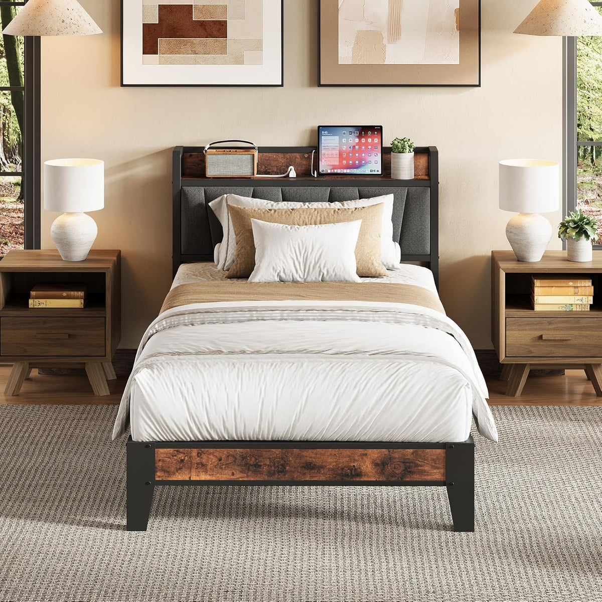 Front view of a bed with white linens, gray padded headboard panels and dark metal frame with rustic wood accents.
