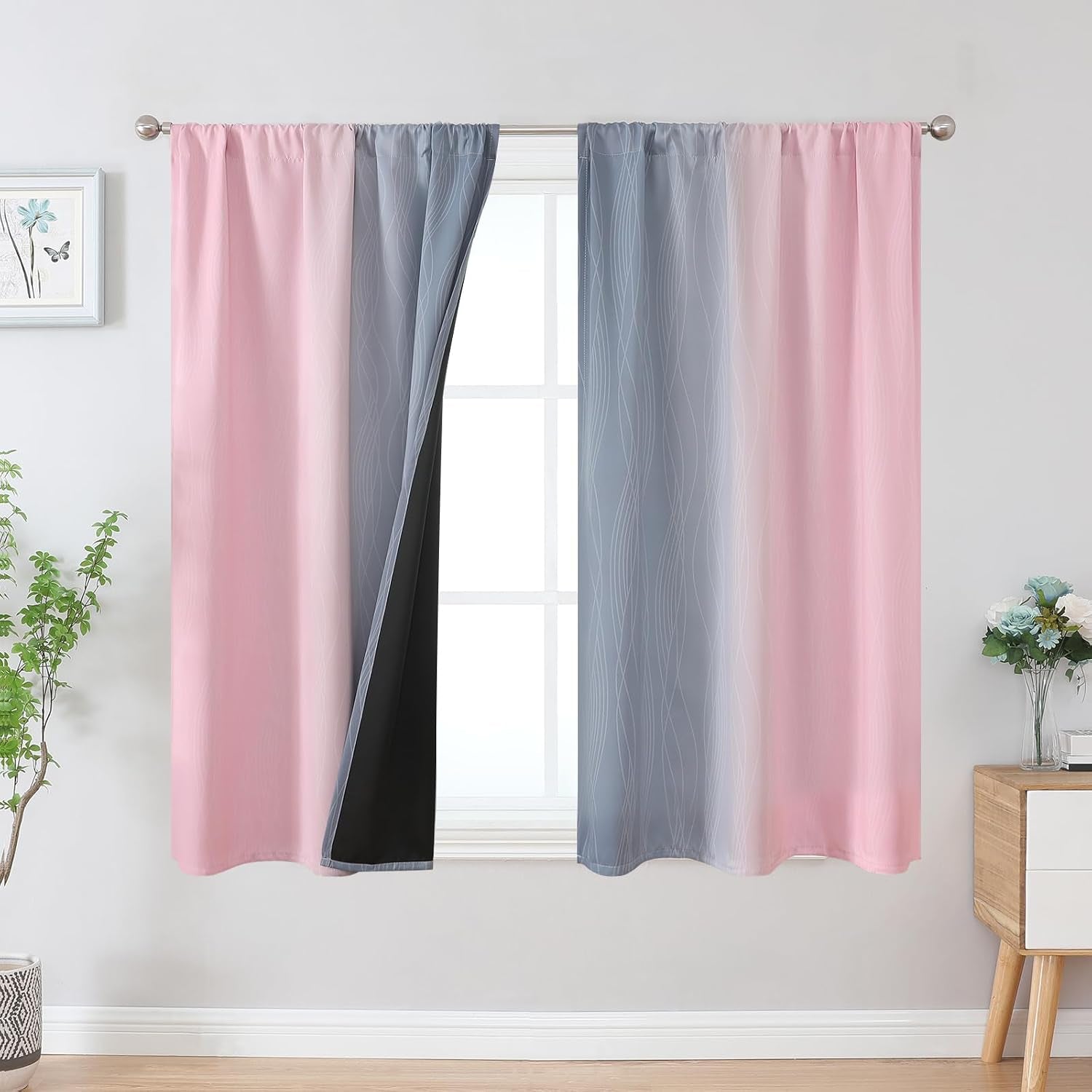Window with pink-to-gray ombre rod-pocket curtains showing black backing on turned-back panel