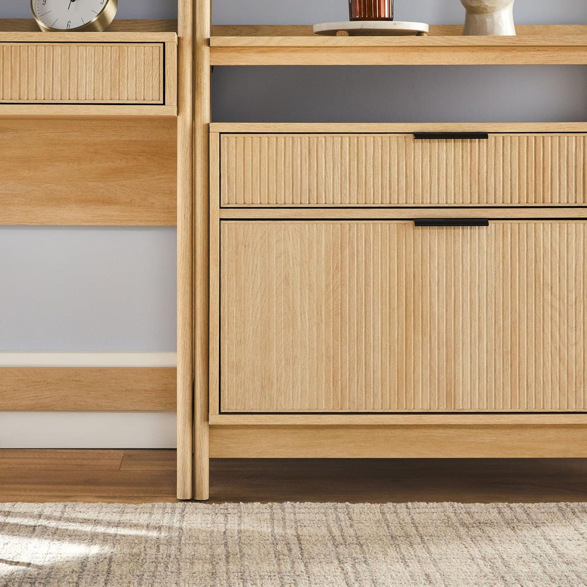 Close-up view of textured vertical reeded drawer fronts and the lower cabinet in a light wood finish.
