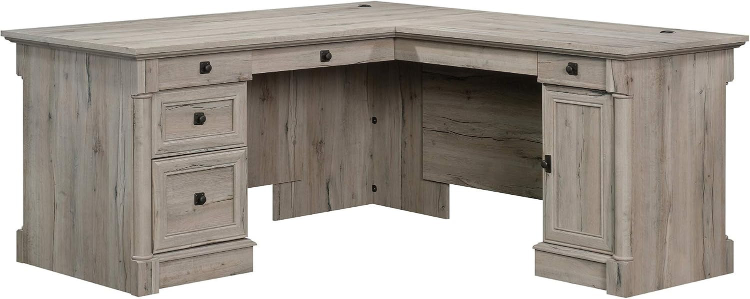 L-shaped wooden desk in a weathered gray finish with three left drawers and a right-side cabinet.