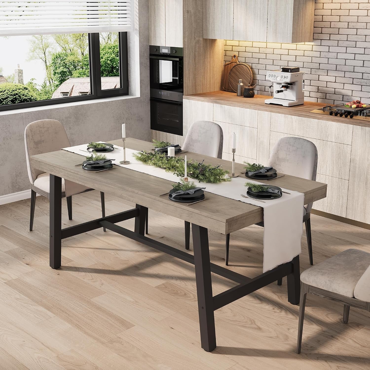 Light wood-top dining table with black metal trestle base styled with runner and place settings in a kitchen