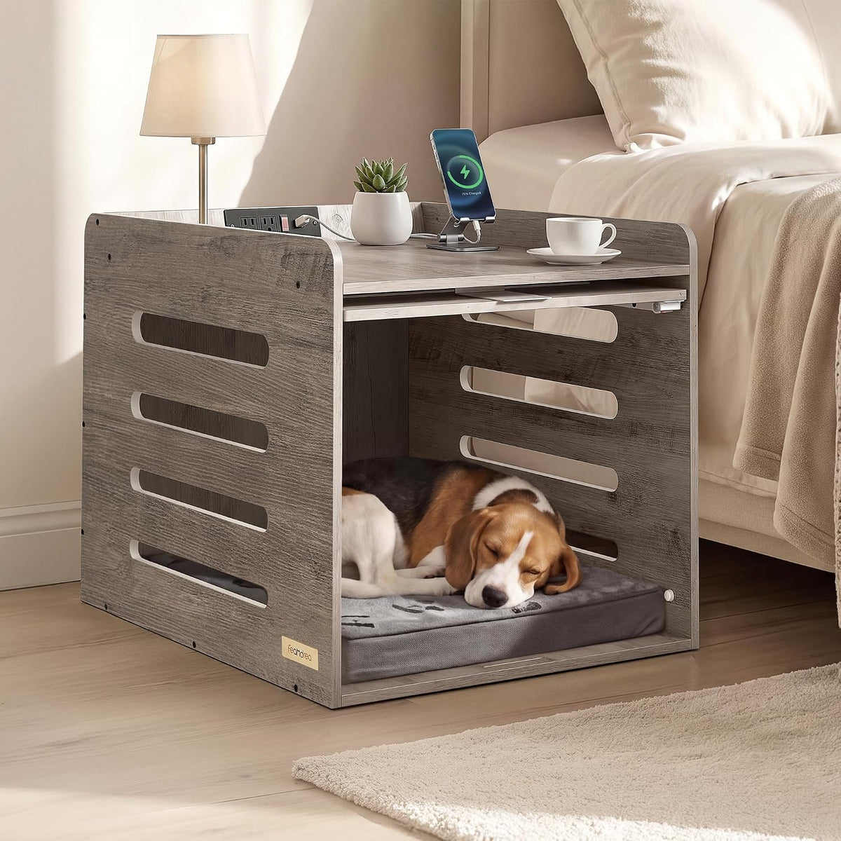 Wooden bedside-style dog crate used as an end table with a sleeping beagle on a cushion inside and a lamp and phone on top.