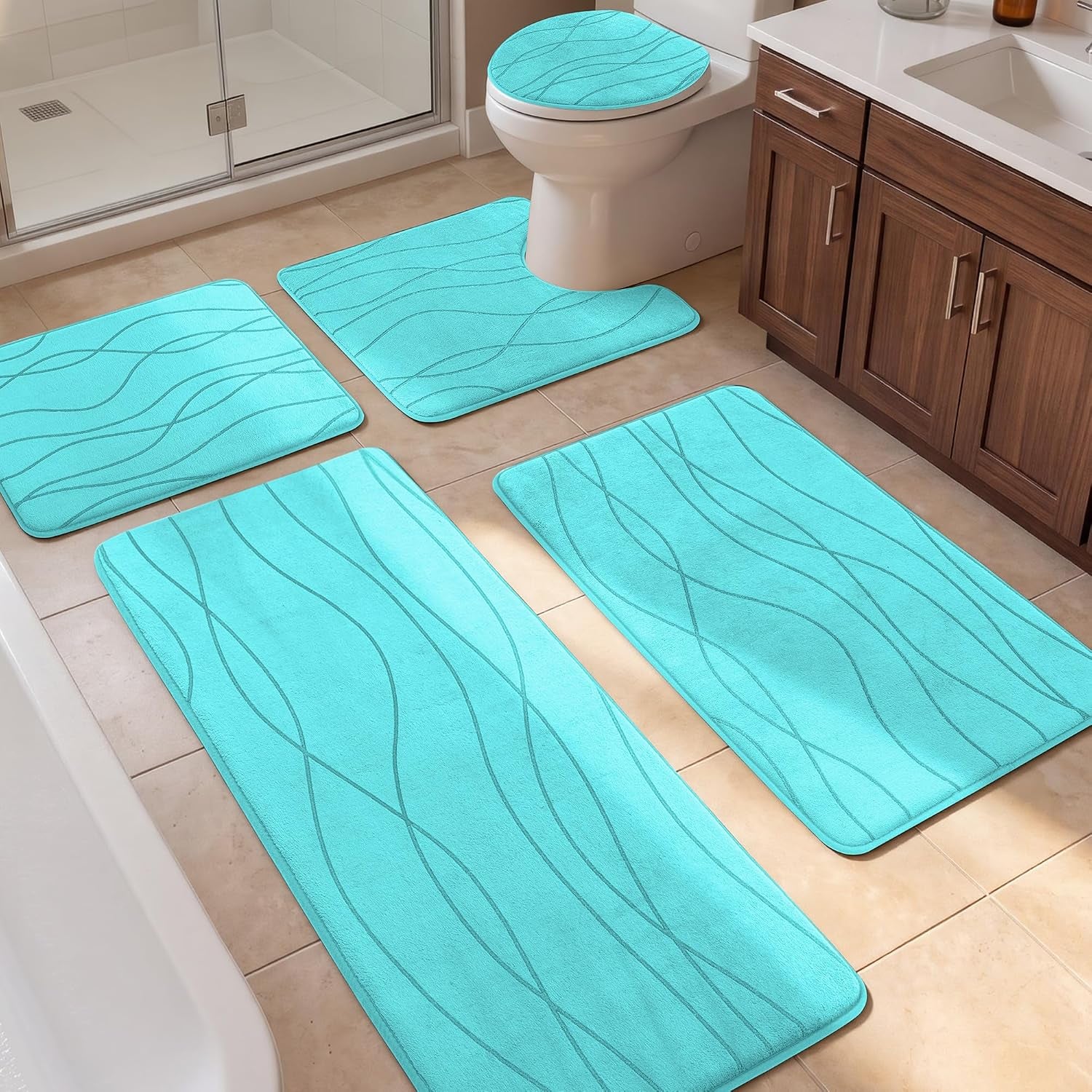 Bathroom floor with a five-piece aqua mat set arranged around a toilet, shower and vanity.