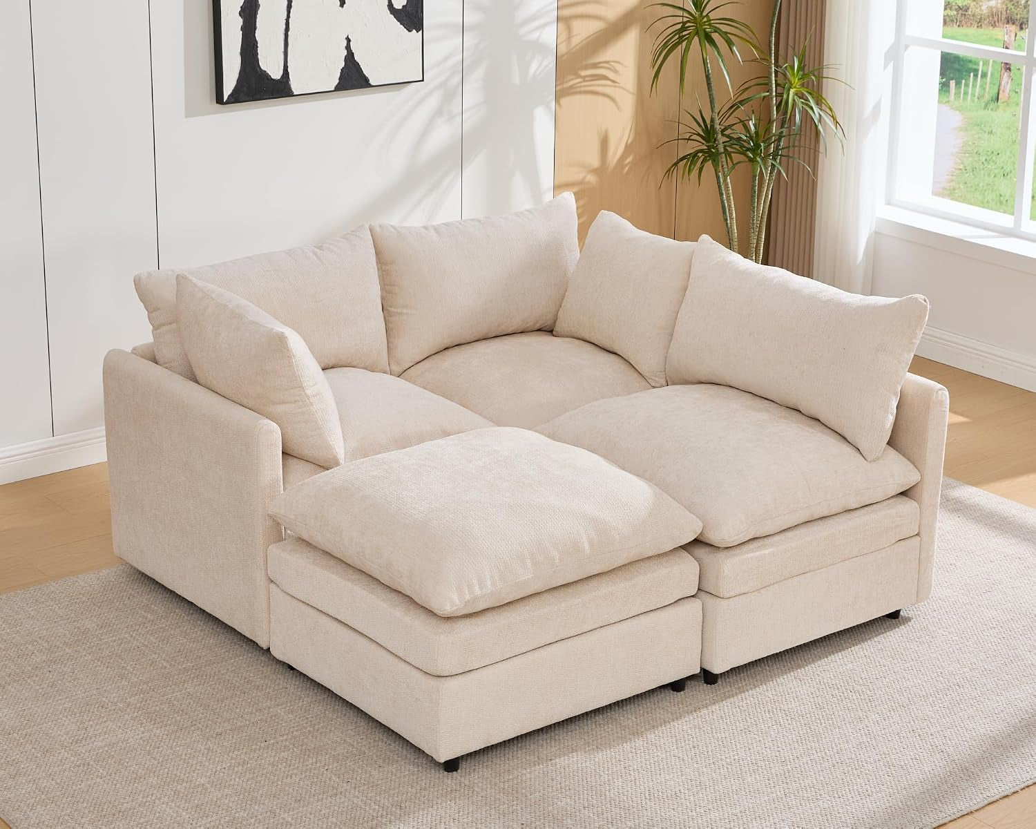 Cream three-seat sectional arranged with an ottoman as a left-side chaise.