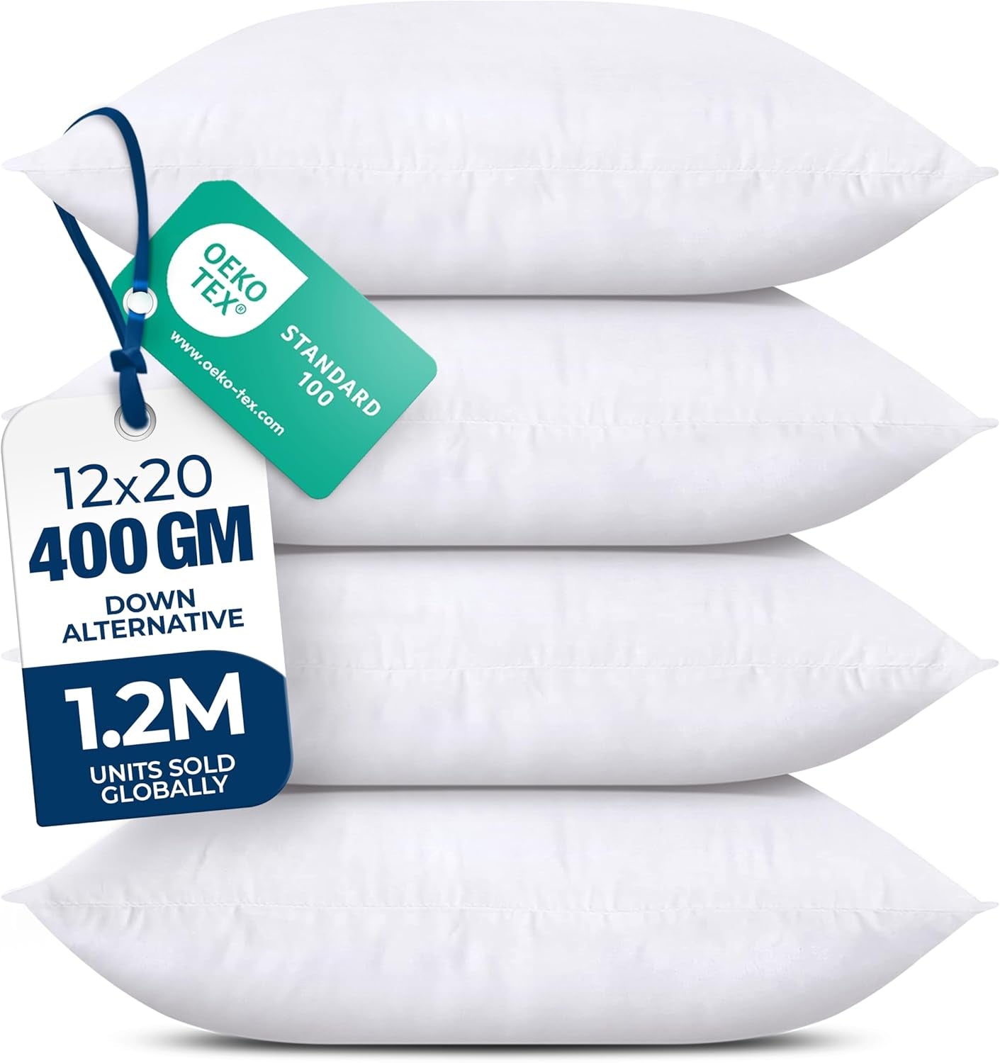 Cropped right-side view of four stacked white pillows with a blue ribbon and green tag draped over the top pillow.