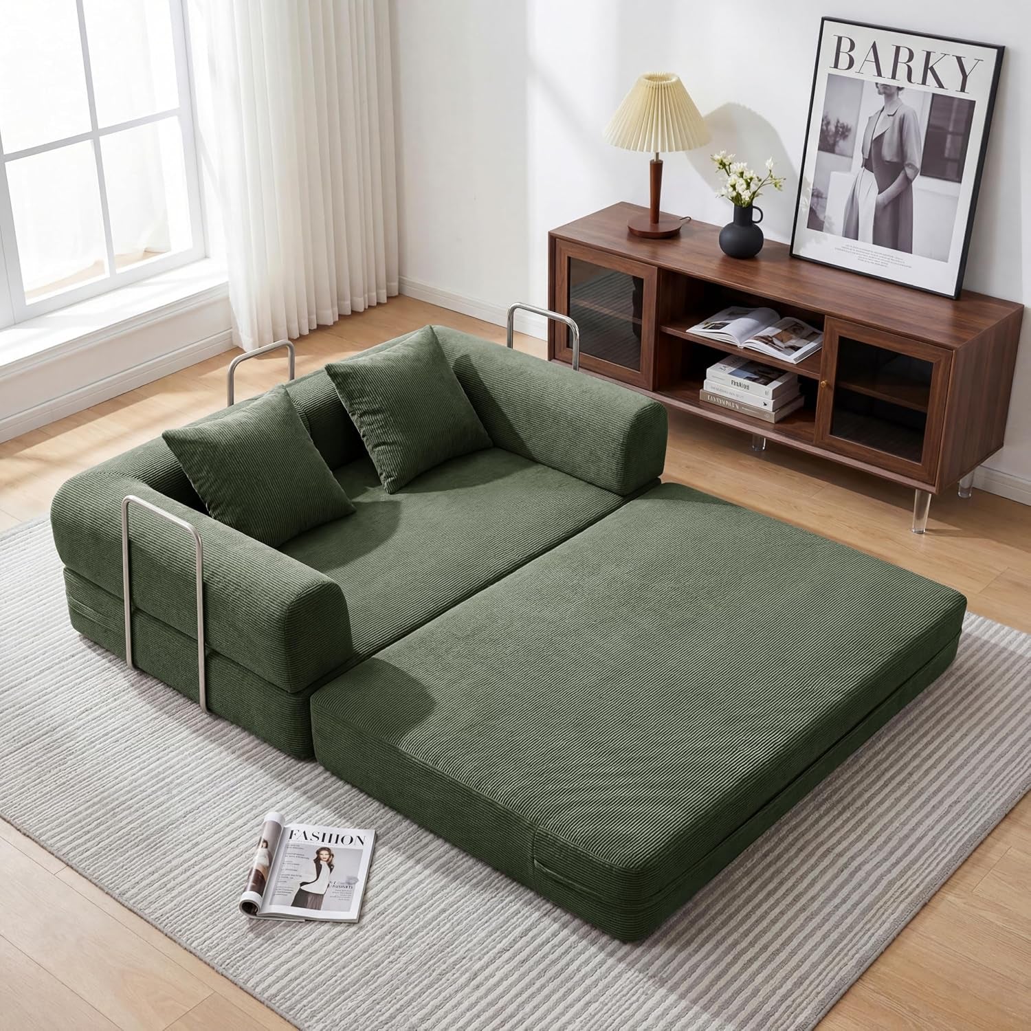 Green corduroy sofa converted into a low-profile bed on a rug, shown from above.