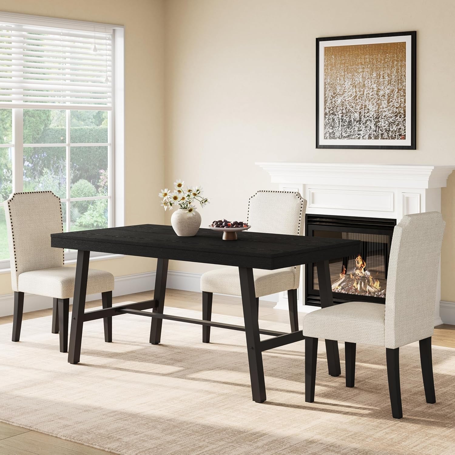 Black-finished rectangular dining table with black metal legs staged with four beige chairs and a vase centerpiece.