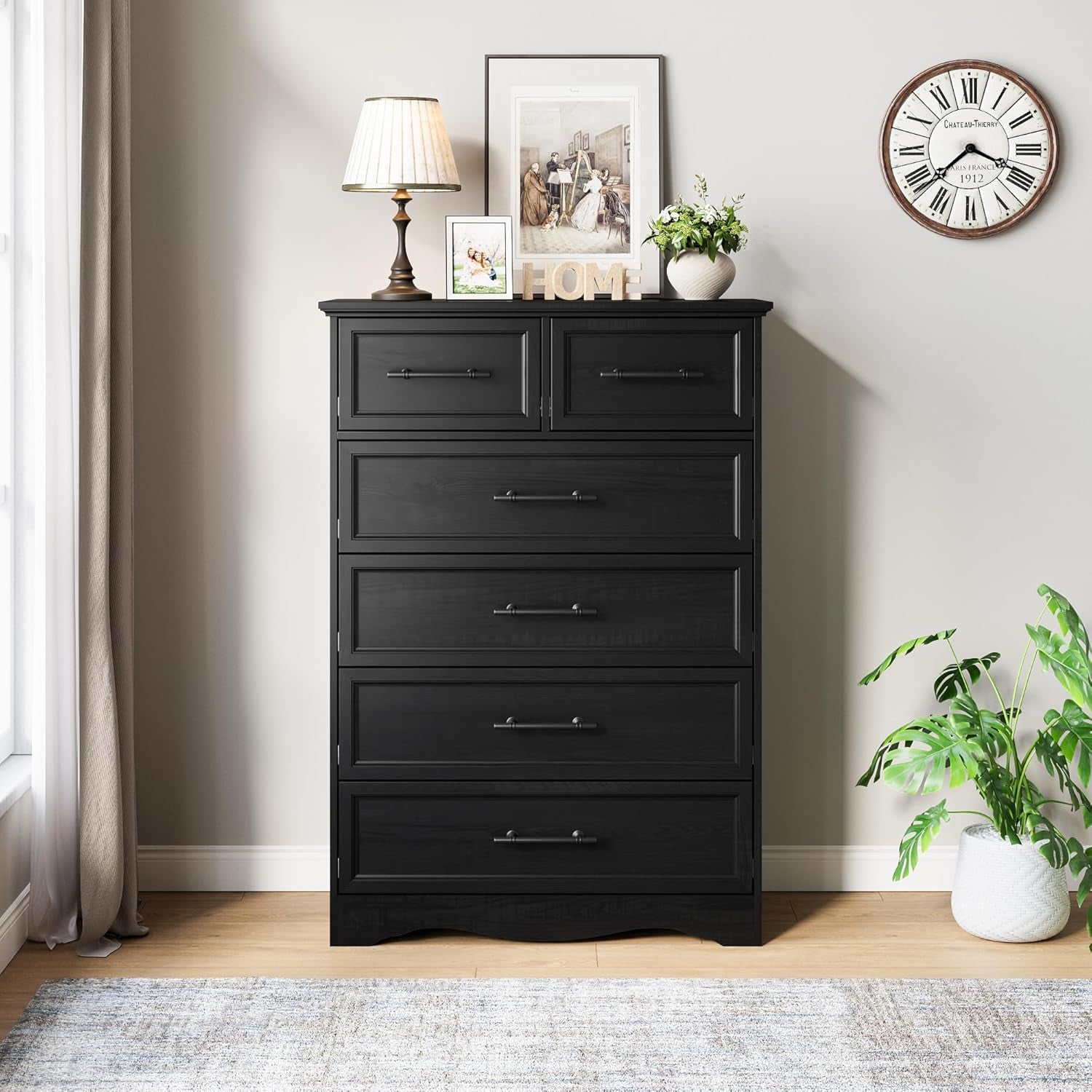 Black 6-drawer chest centered against a wall with decorative clock and plant