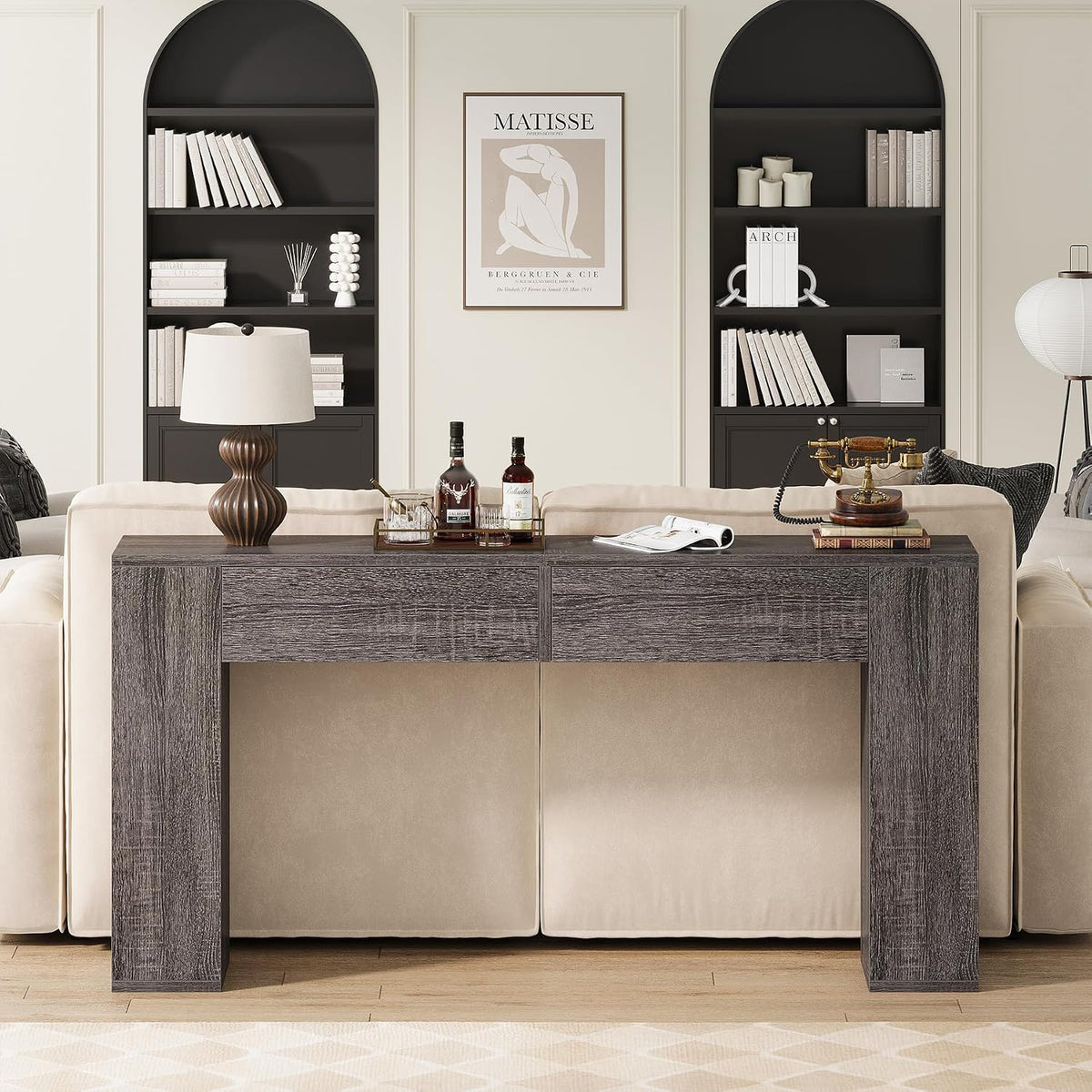 Grey console table placed behind a beige sofa in a styled living room straight-on view.