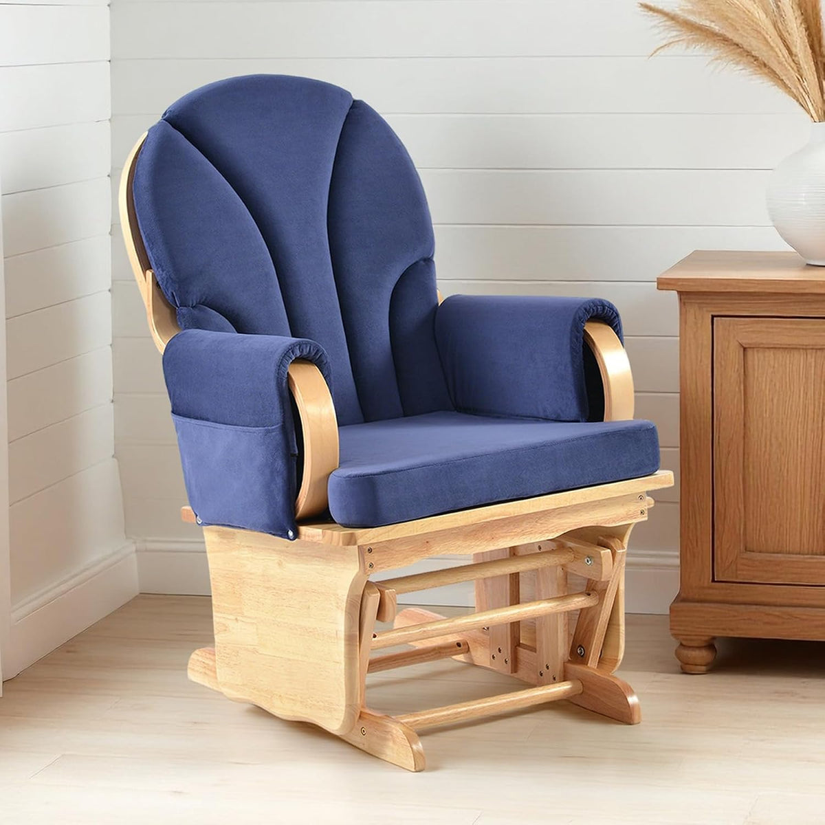 Side view of a light-wood glider chair with deep navy cushions and visible rocker base