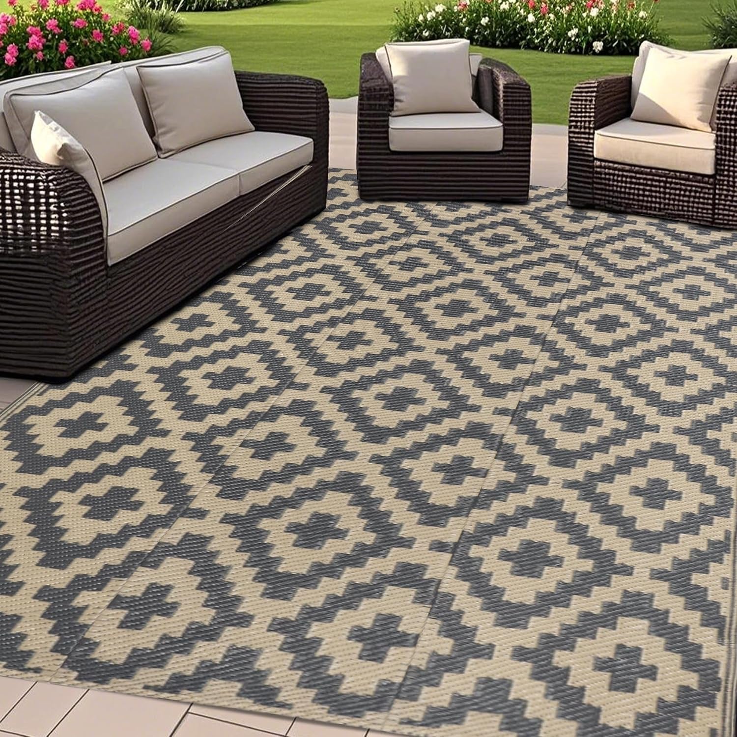 Wide patio view with seating and a large cream-and-charcoal geometric outdoor rug covering the floor.