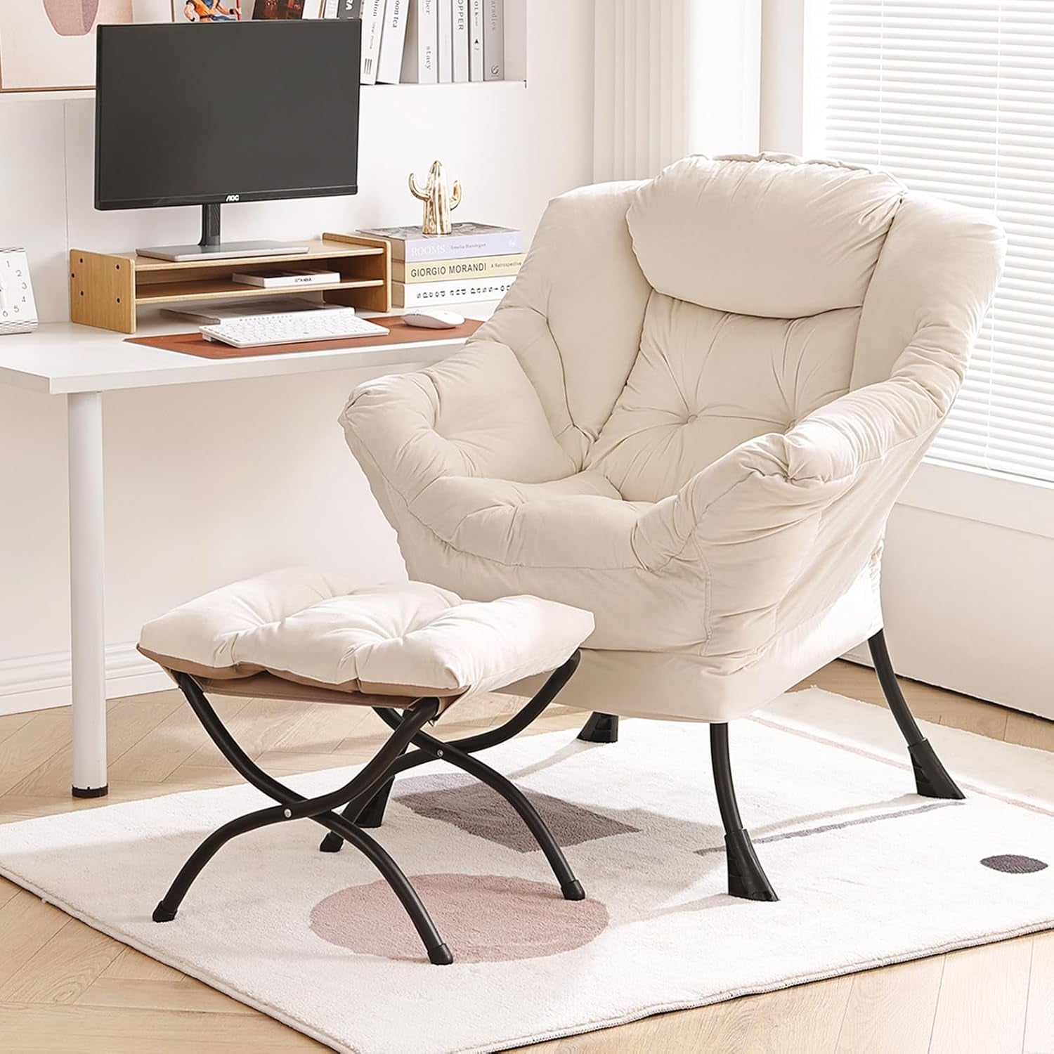 Cream upholstered lounge chair with matching ottoman beside a desk in a bright room