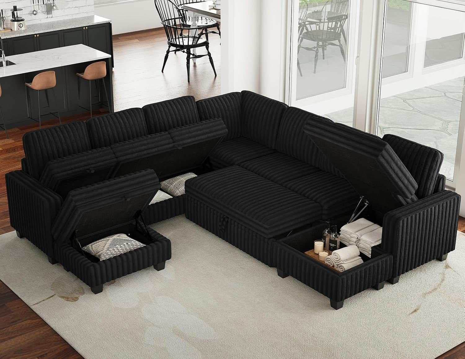 Black corduroy sectional with multiple storage compartments open showing folded linens and pillows inside