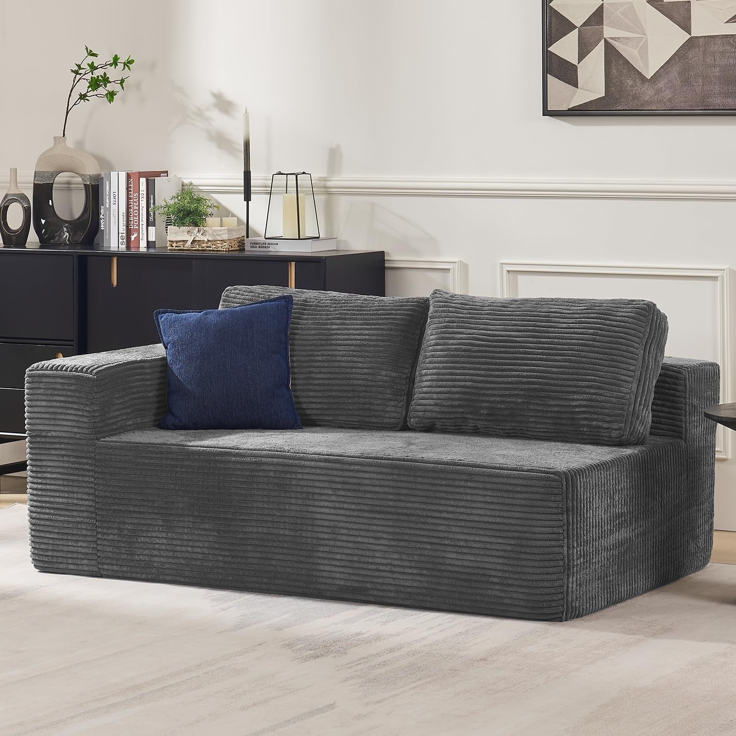 Dark gray corduroy-textured modular sofa section with two back cushions and a blue accent pillow.