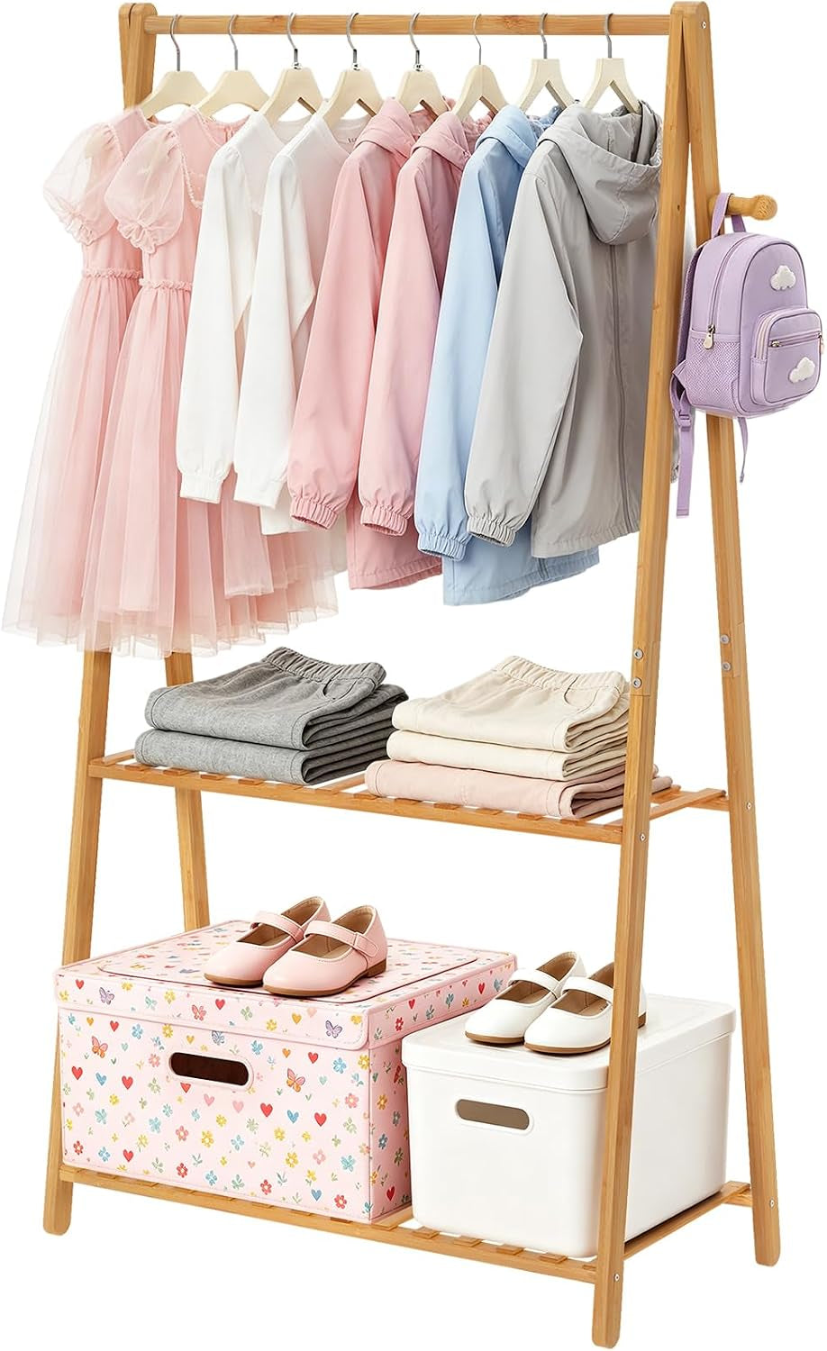Studio image of a two-tier bamboo garment rack with children's jackets on the bar and folded clothes and boxes on shelves.