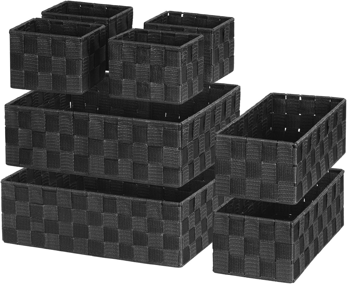Angled arrangement of four black woven polypropylene baskets shown empty on a white background.
