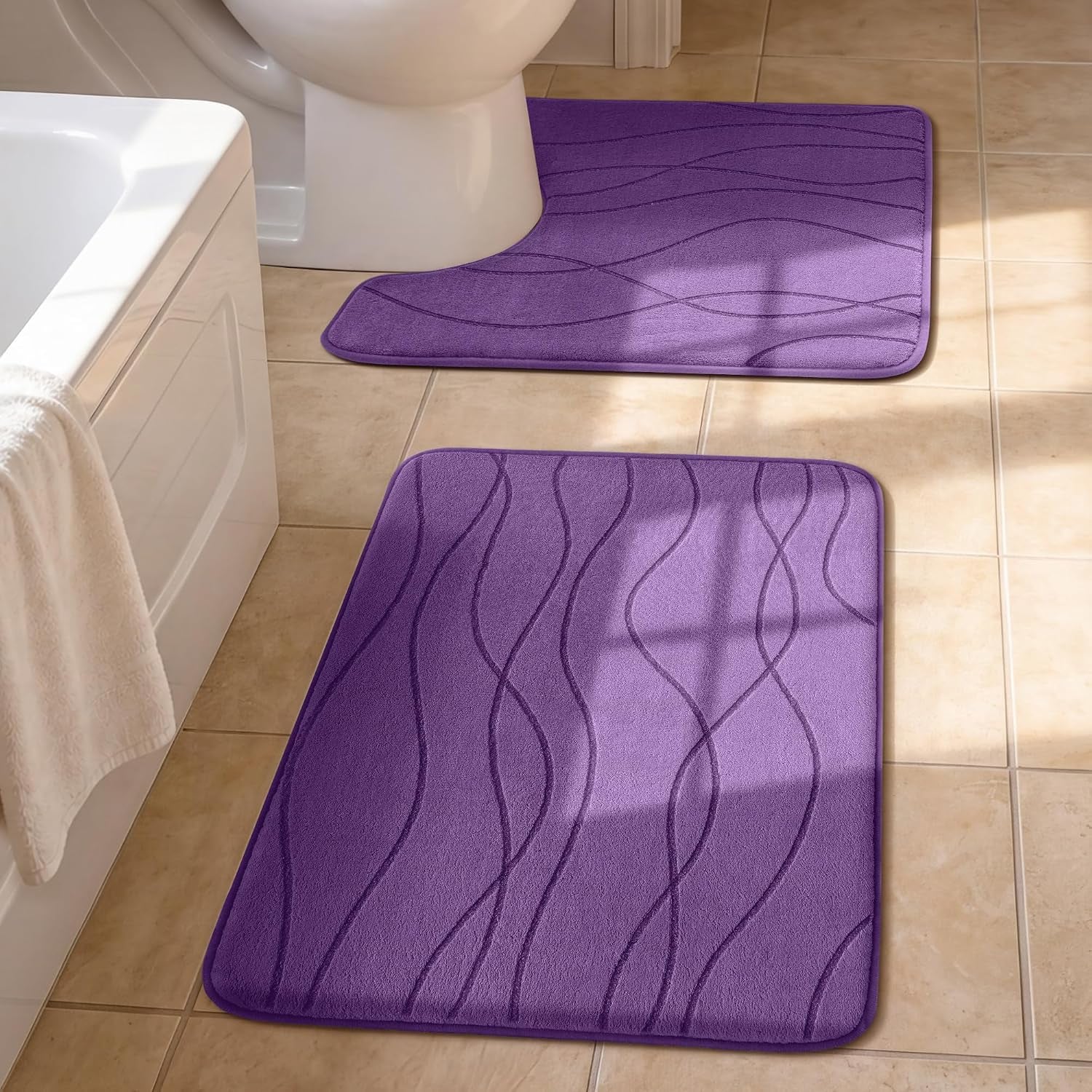 Two purple bath mats on tiled bathroom floor beside a tub and toilet, wavy embossed lines visible
