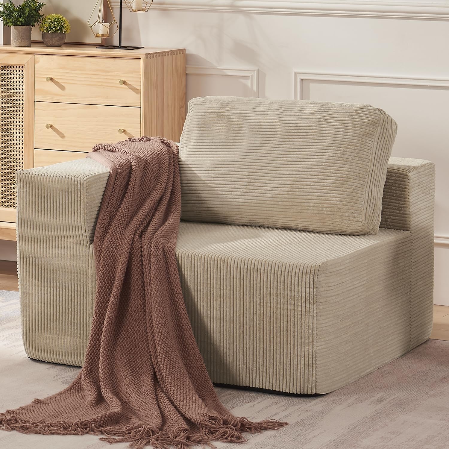 Side view of a beige modular seat with a dusty rose throw cascading to the floor.