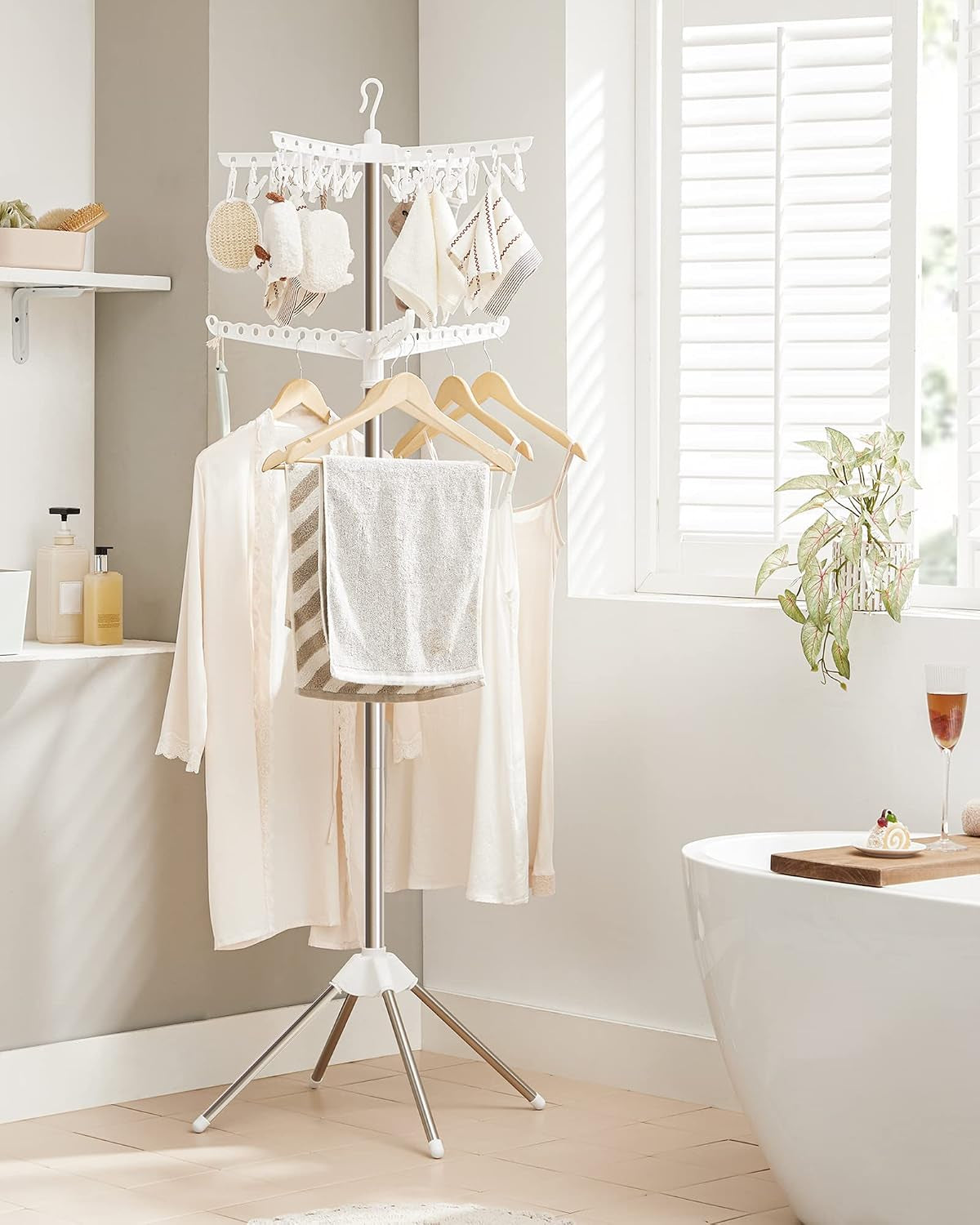 Drying rack showing hangers and a towel on the lower rotary arm in a bathroom-like setting