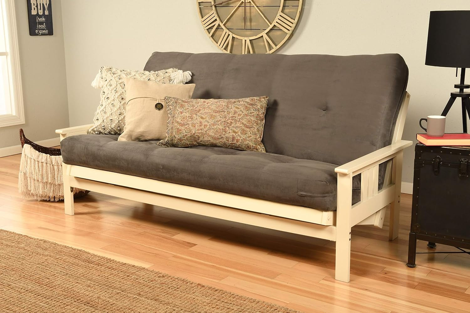 Dark charcoal futon mattress on a cream-painted mission-style hardwood frame with decorative pillows