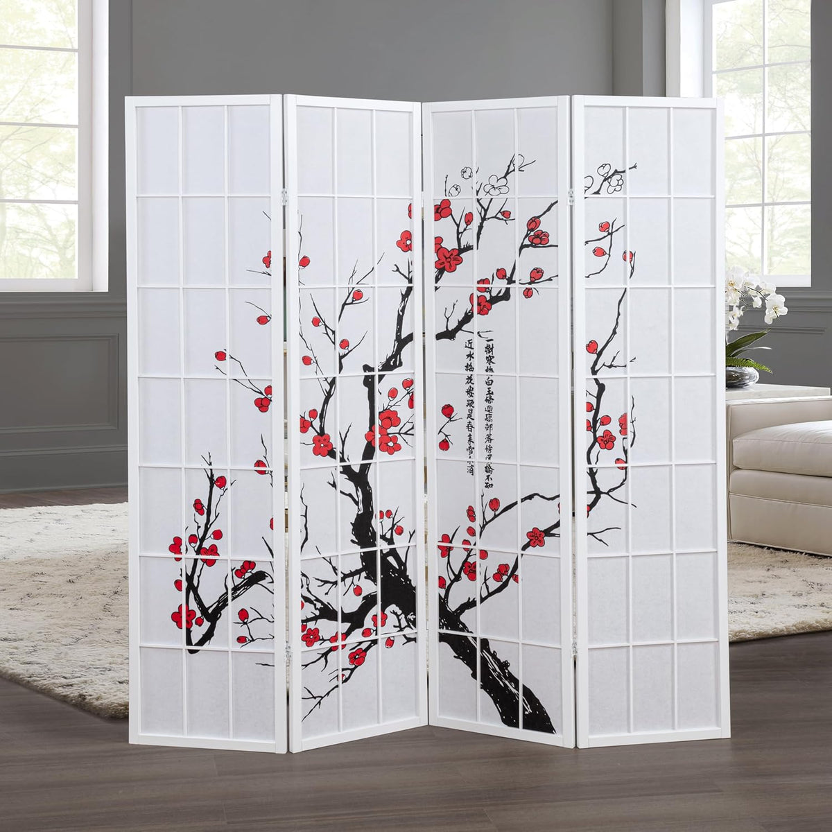 Staged living-room shot of a white-framed four-panel shoji divider with plum blossom print between two tall windows.