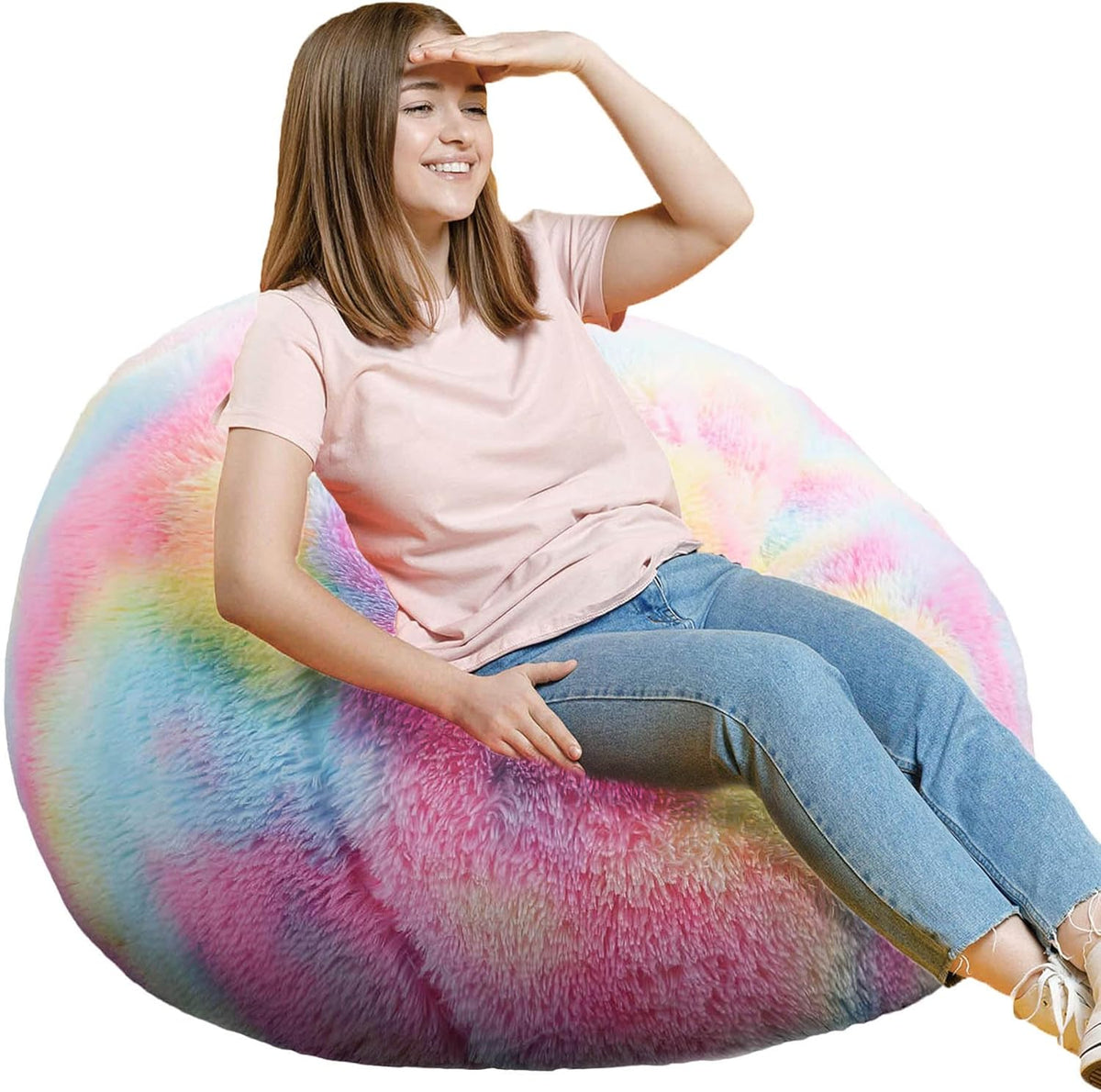 Teen sitting on a multicolor pastel rainbow fluffy round bean bag, smiling and leaning back.