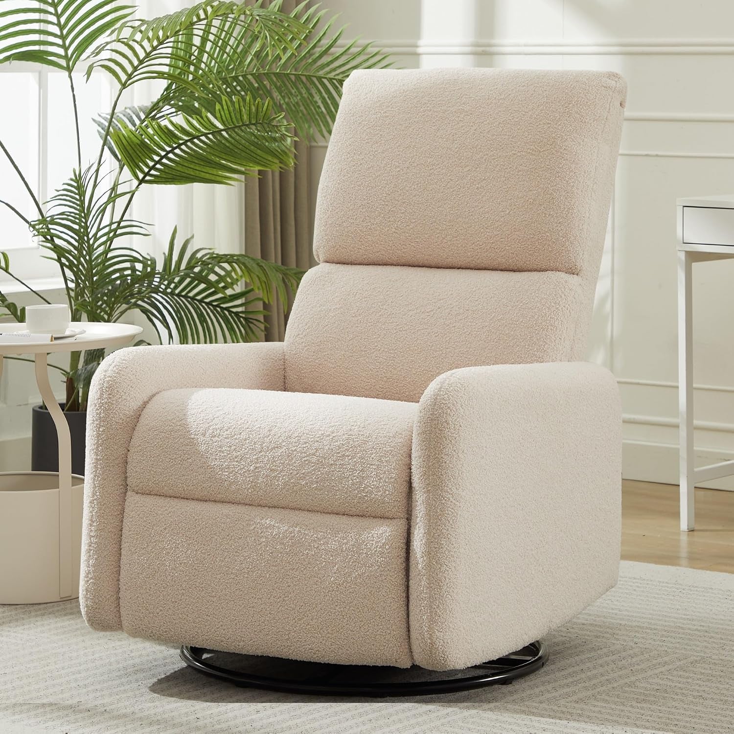 Cream sherpa nursing rocker displayed three-quarter front with cushioned seat and visible black swivel base.