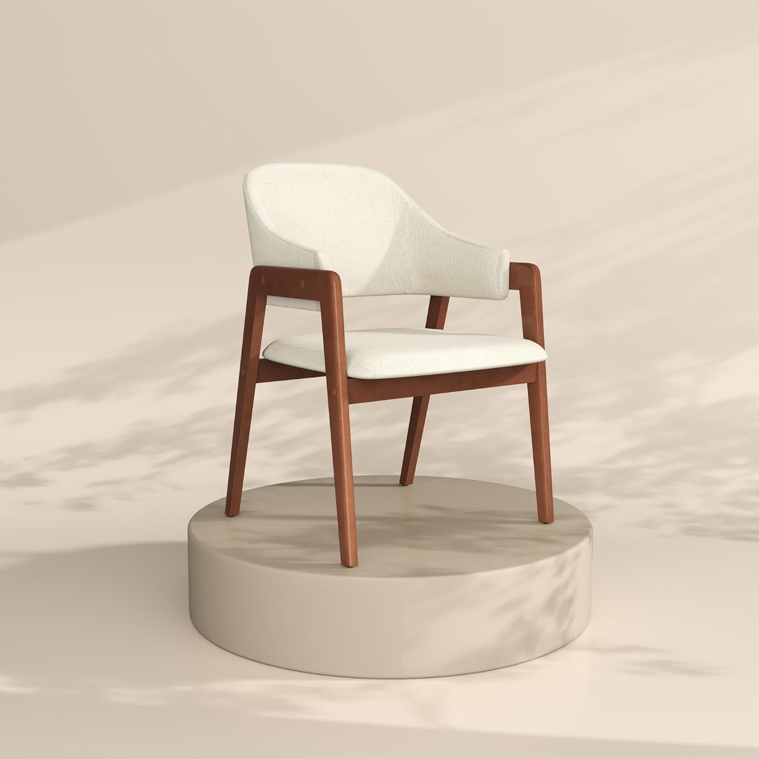 Single cream-upholstered armchair on a round pedestal against a neutral backdrop.