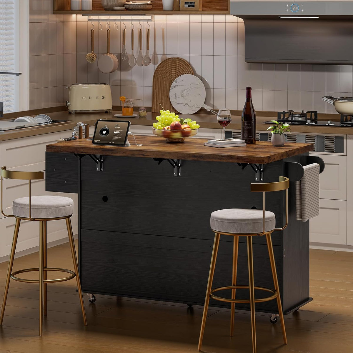 Kitchen island with dark black base and rustic wood top set in a modern kitchen with two gold stools.