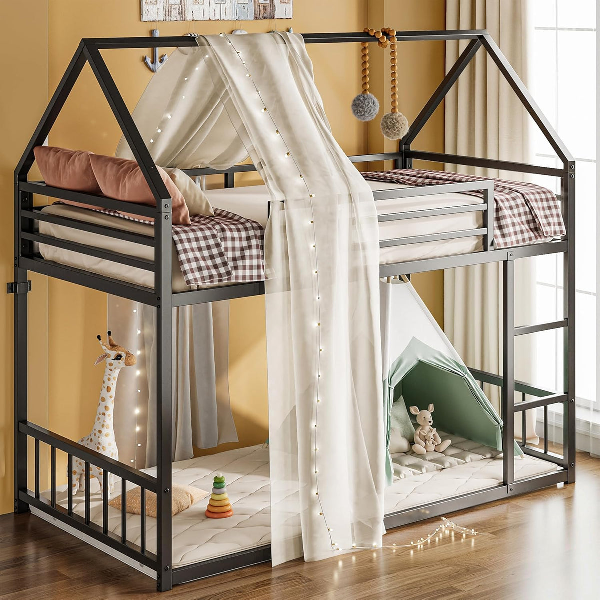 Dark metal twin-over-twin house bunk bed with sheer canopy drape and play area below