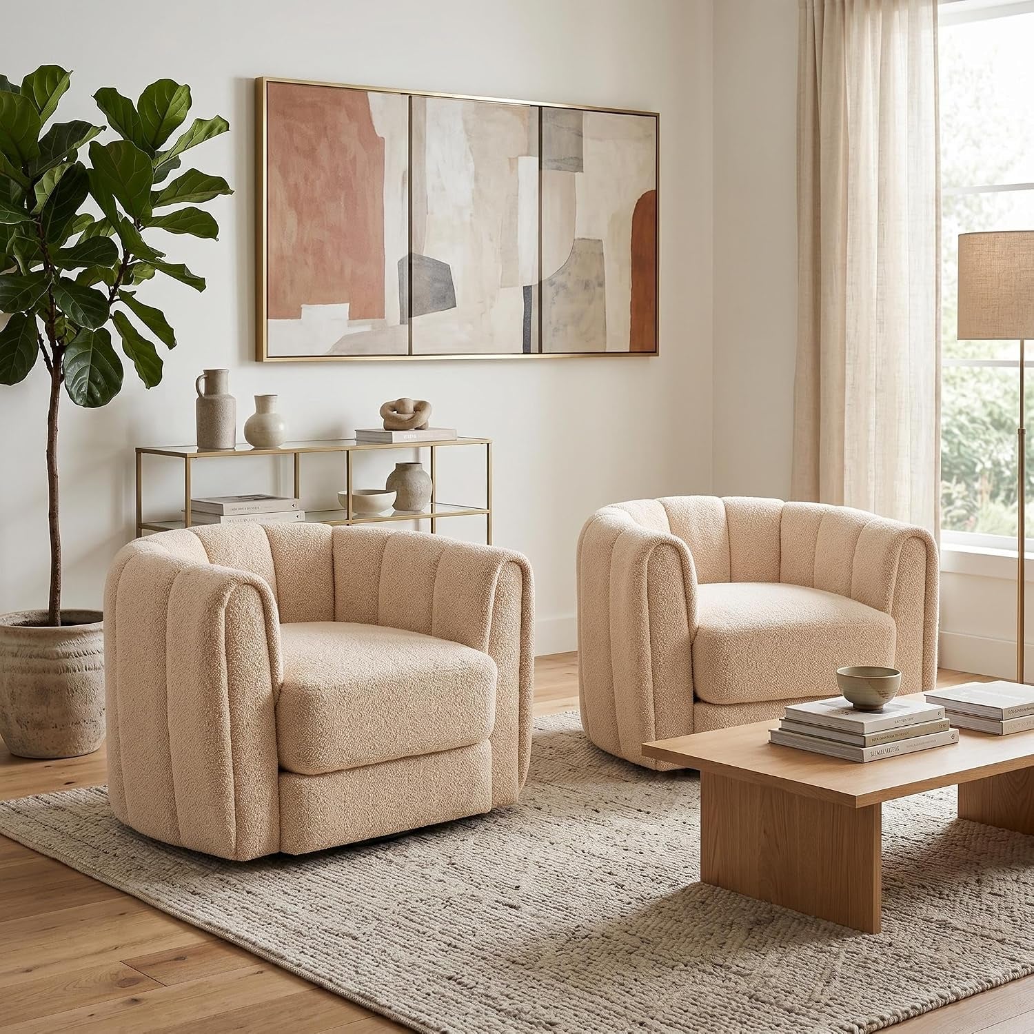 Pair of rounded barrel swivel chairs in pale beige fleece arranged by a low wood coffee table in a sunlit living room.