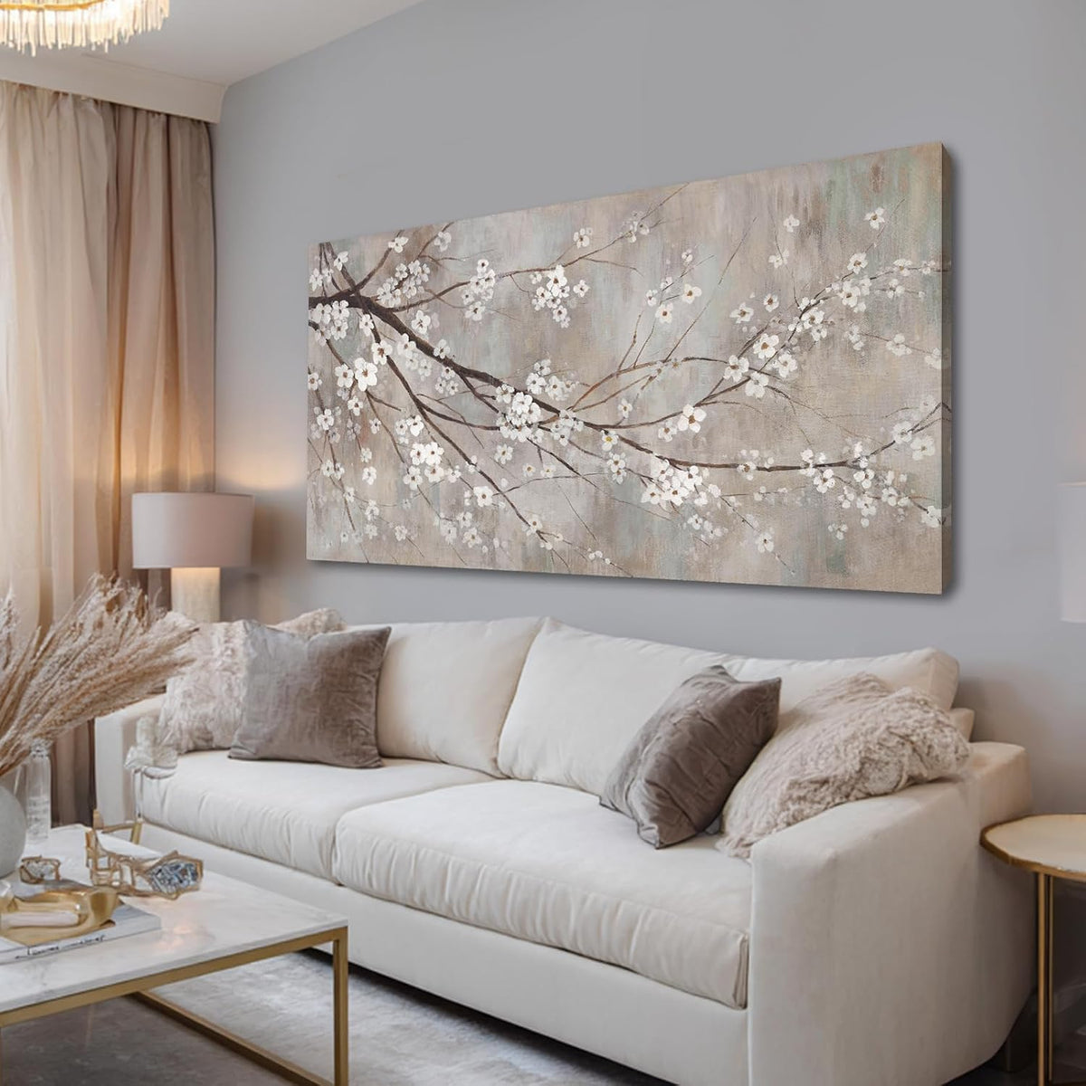 Plum blossom canvas wall art above a cream sofa in a softly lit living room.