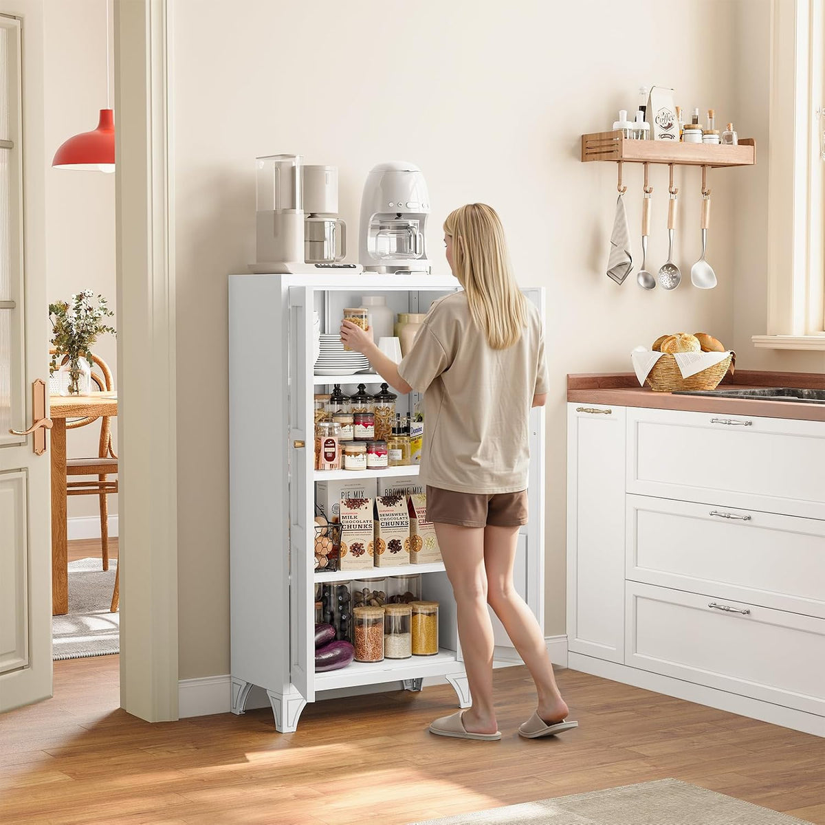White metal storage cabinet in a kitchen scene with a person reaching into the top shelf, front view