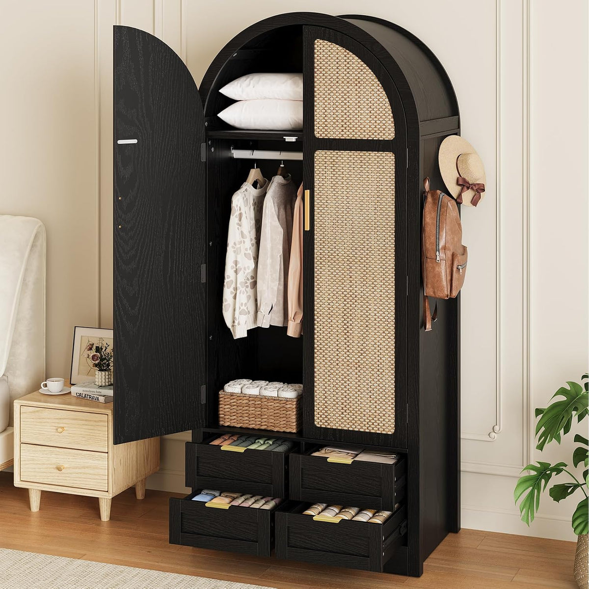 Tall black arched wardrobe with left door open, woven rattan panel on right door, four lower drawers pulled out and hanging