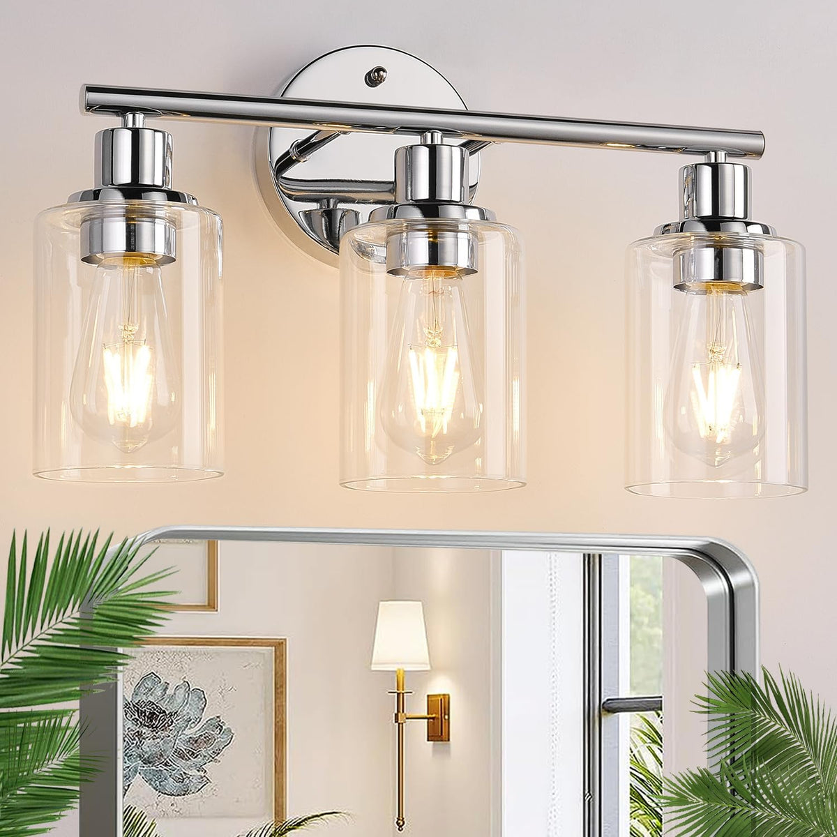 Close view of a three-light chrome vanity fixture with clear cylindrical shades and glowing bulbs above a mirror.
