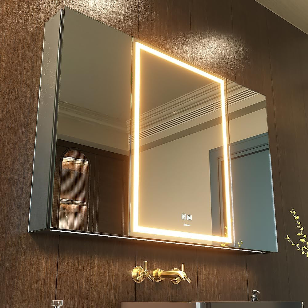 Wall-mounted mirrored cabinet with warm rectangular LED inset, touch icons at lower center and gold wall faucet below.