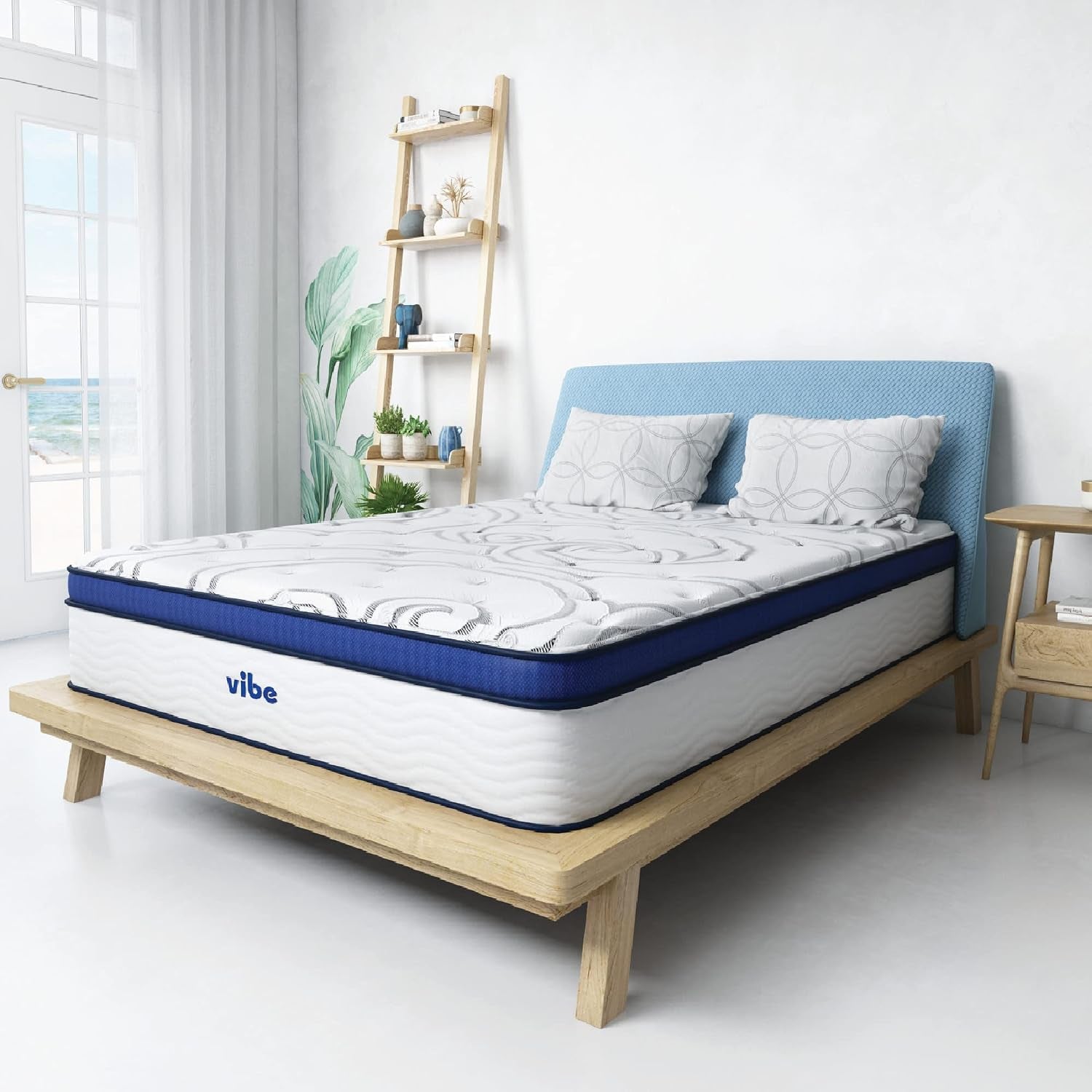 White mattress with blue top border on a light wood platform bed in a bright bedroom setting, angled view