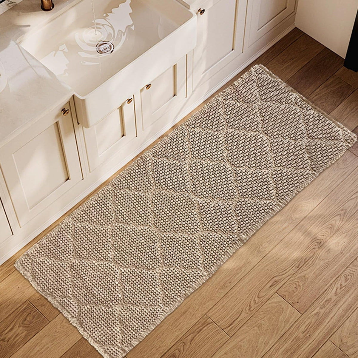 Top-down view of a tan waffle bath mat with a geometric raised pattern beside a sink