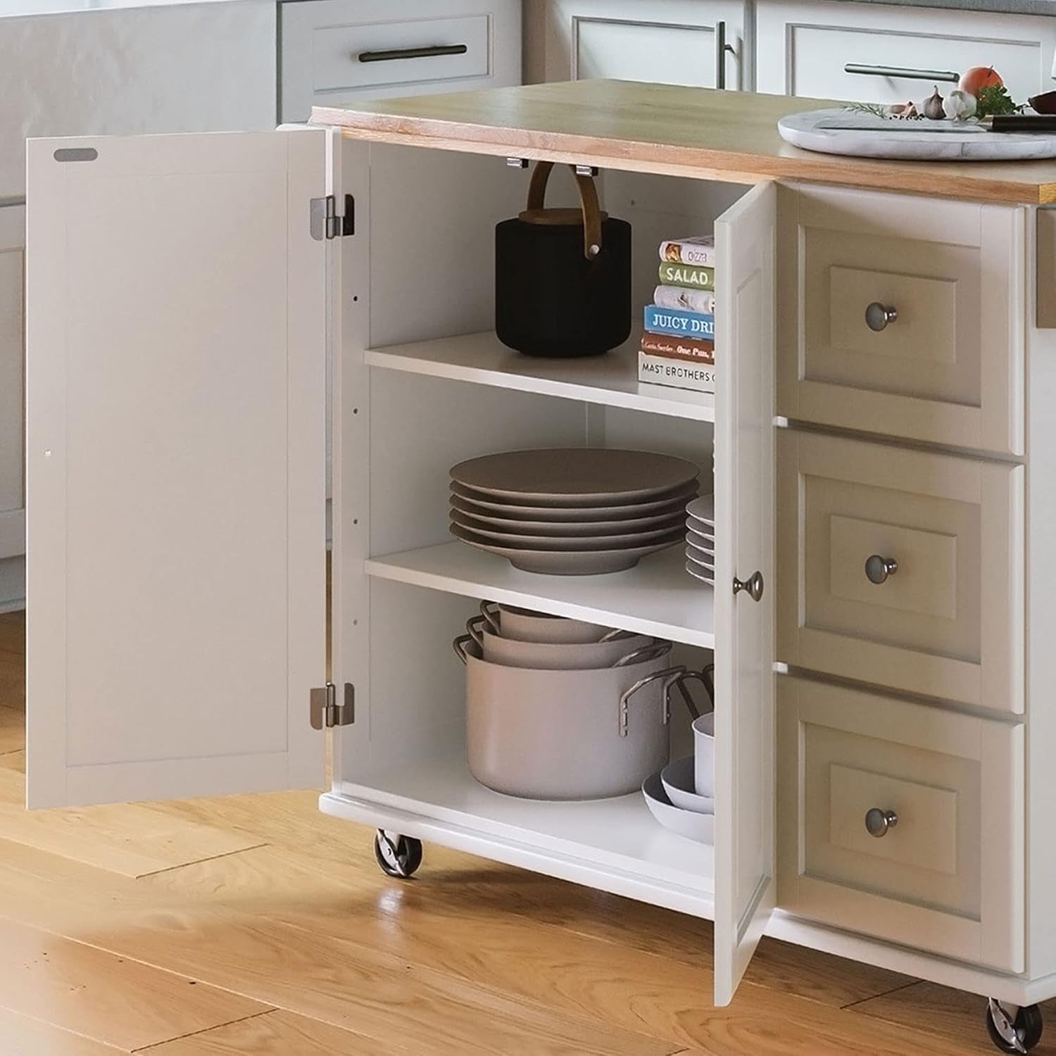 Interior view with doors open showing two adjustable shelves stocked with plates and pots beside a stack of three drawers