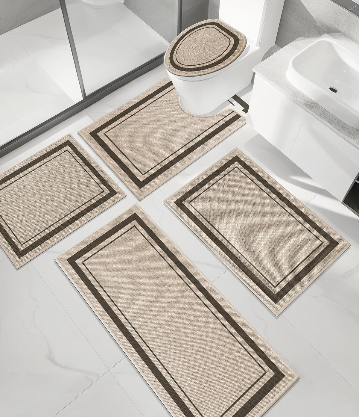 Top-down view of a four-piece beige bathroom set including a contoured mat, two small mats and a long runner on tile floor.
