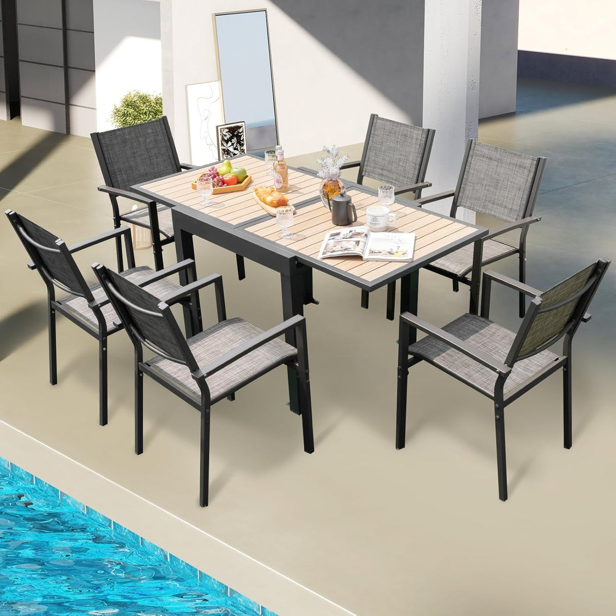 Poolside overhead scene of the extended dark gray table surrounded by six matching gray armchairs.