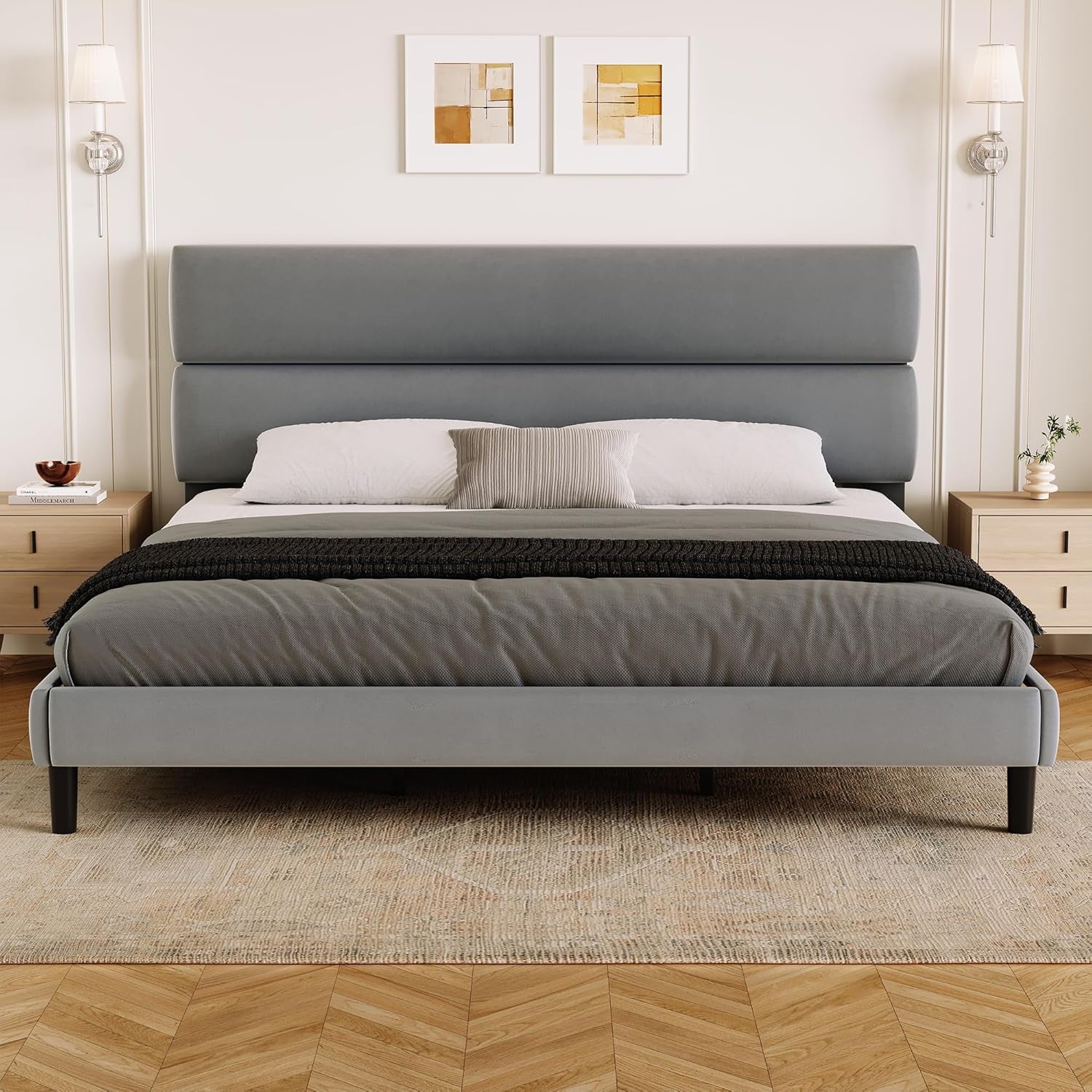 Wide bedroom scene with a gray upholstered platform bed and broad two-section headboard.