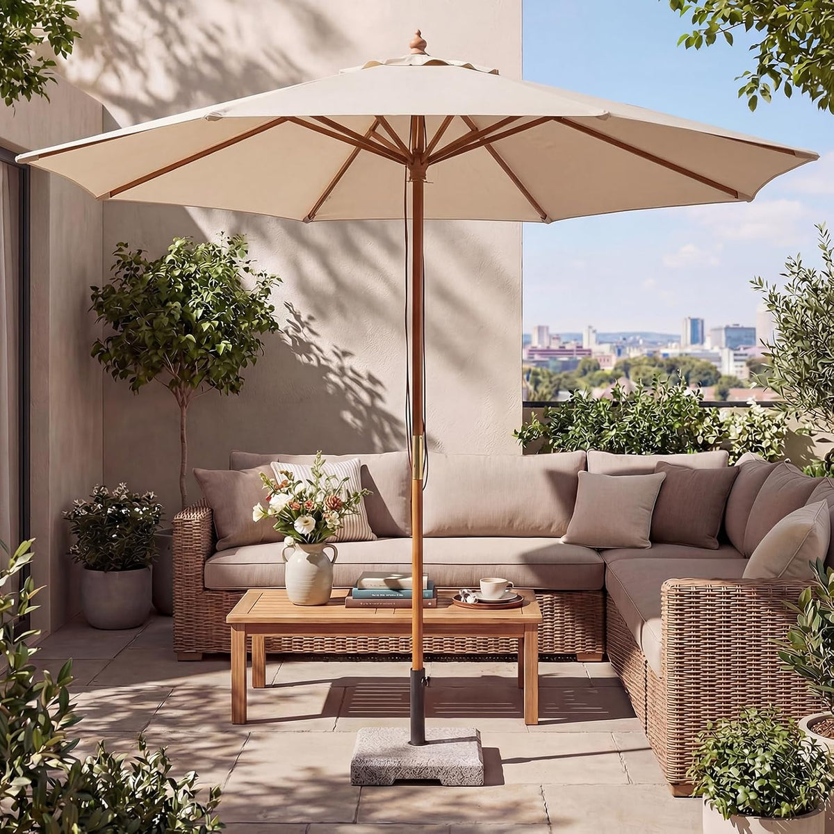Umbrella set up on a balcony beside a beige sectional sofa and coffee table with a city skyline in the background.