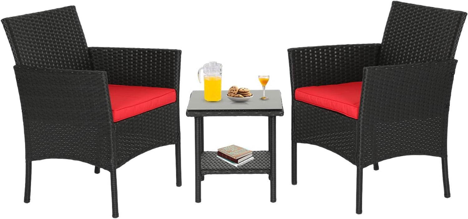 Two black woven armchairs with red seat cushions flanking a small square glass-top table with drinks.