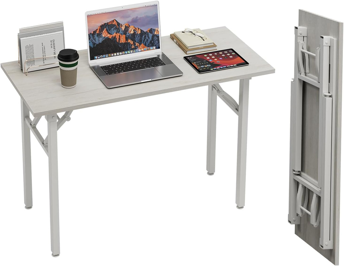 Three-quarter shot of a light wood‑grain tabletop desk set up with laptop and tablet; a folded panel with collapsed legs