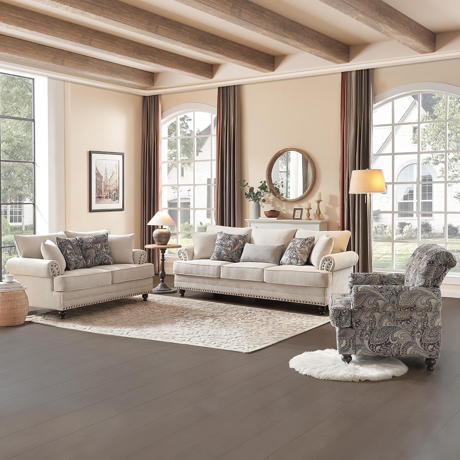 Living room scene with matching light beige sofa and loveseat, patterned armchair and large windows.